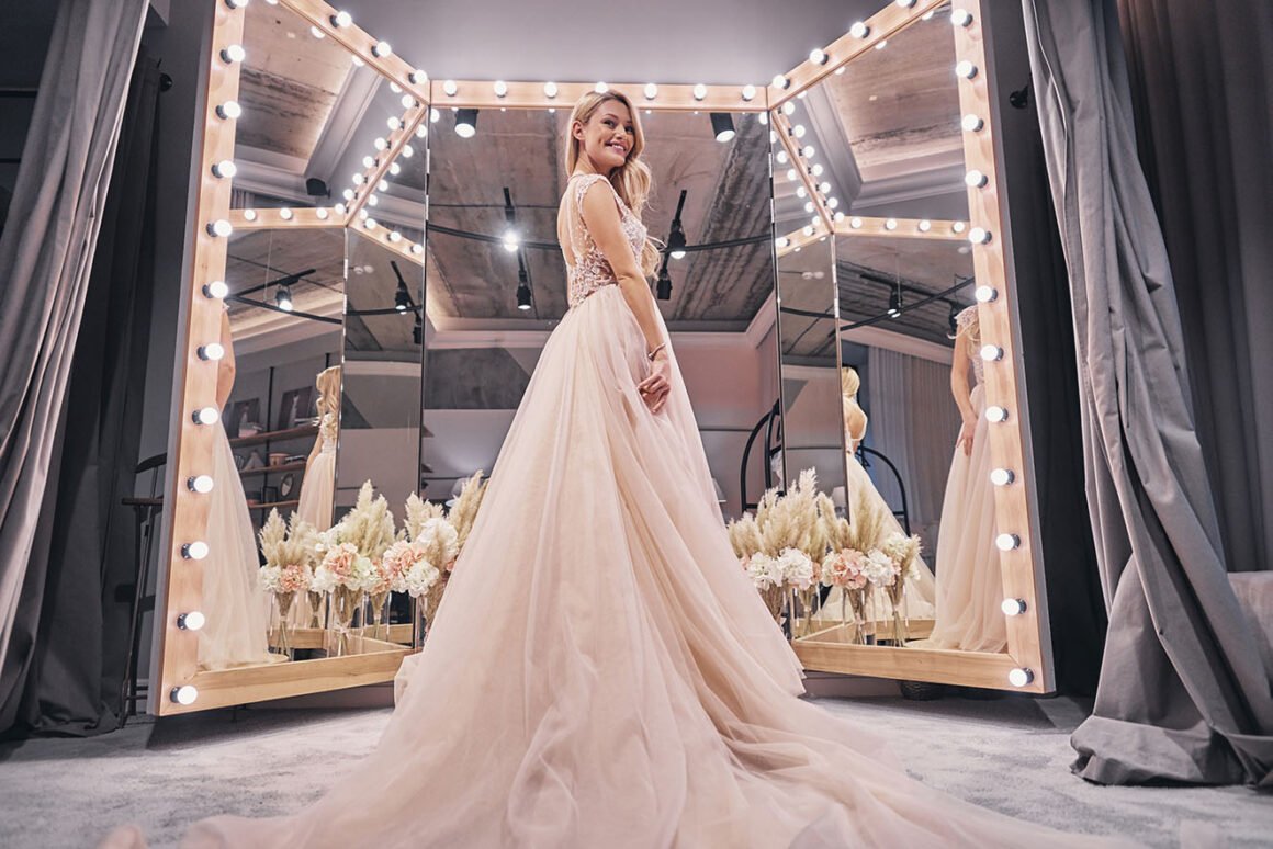 Bride in a lace gown in a mirrored, light-framed bridal suite at Willow Creek Inn
